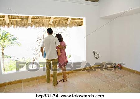 Picture - Couple looking through a window. Fotosearch