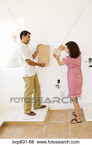 Couple matching tiles on the wall View Large Photo Image Stock Photo - Couple matching tiles on the wall. Fotosearch
