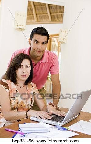 Stock Photograph - Couple online shopping with a laptop. Fotosearch