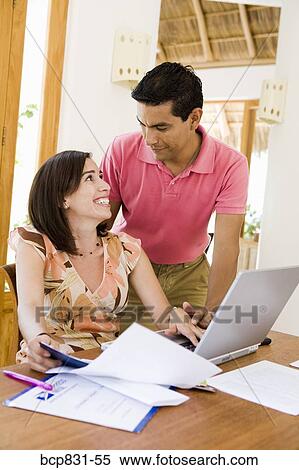 Couple online shopping with a laptop View Large Photo Image Stock Photography - Couple online shopping with a laptop. Fotosearch