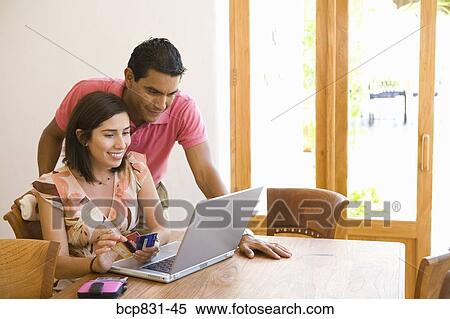Couple using a credit card for internet shopping View Large Photo Image Stock Photography - Couple using a credit card for internet shopping. Fotosearch