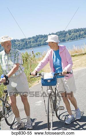 Couple walking on the road with their bicycles, Washington State, USA View Large Photo Image Stock Photography - Couple walking on the road with their bicycles, Washington State, USA. Fotosearch