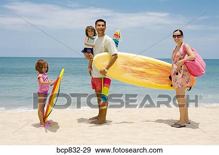 Stock Photo - Couple with their children standing on the beach. Fotosearch