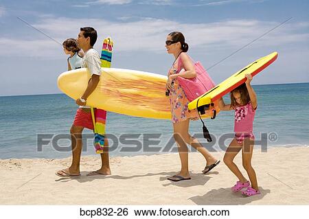 Couple with their children walking on the beach View Large Photo Image Stock Photograph - Couple with their children walking on the beach. Fotosearch