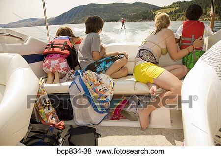 Stock Photo - Family in a motorboat and looking at a person waterskiing, Lake Chelan, Washington State, USA. Fotosearch