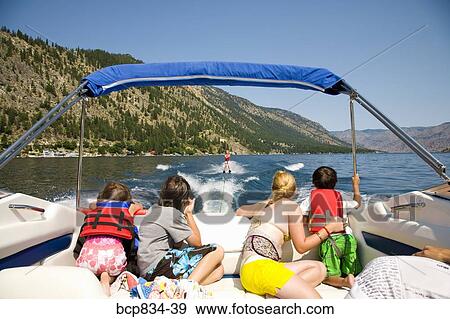 Family in a motorboat and looking at a person waterskiing, Lake Chelan, Washington State, USA View Large Photo Image Stock Photo - Family in a motorboat and looking at a person waterskiing, Lake Chelan, Washington State, USA. Fotosearch