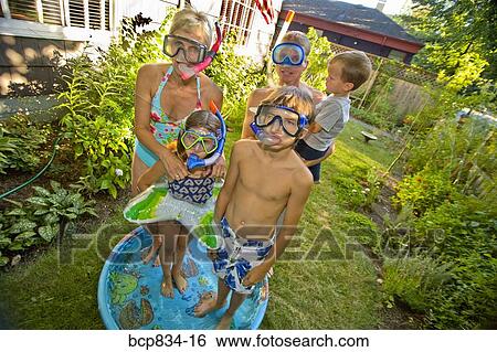 Family wearing snorkels and standing in a wading pool View Large Photo Image Stock Photograph - Family wearing snorkels and standing in a wading pool. Fotosearch