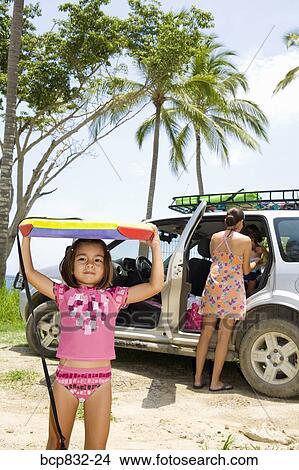 Picture - Girl carrying a body board on the beach. Fotosearch