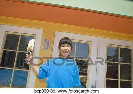 Stock Photography - Girl holding a paintbrush. Fotosearch
