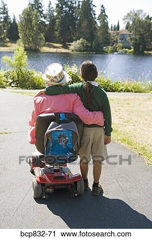 Girl standing with her grandmother sitting in a wheelchair View Large Photo Image Stock Image - Girl standing with her grandmother sitting in a wheelchair. Fotosearch