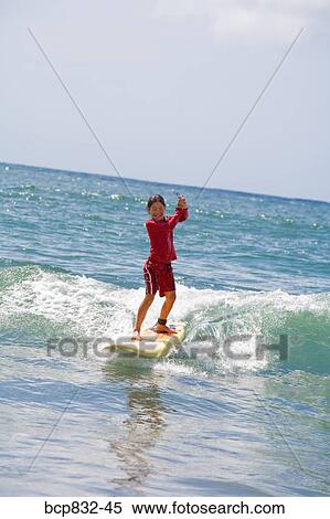 Girl surfing in the sea and holding a mobile phone View Large Photo Image Stock Photography - Girl surfing in the sea and holding a mobile phone. Fotosearch