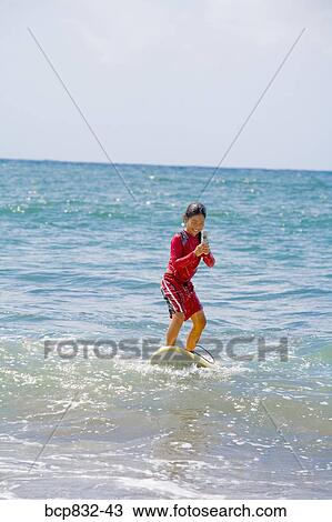 Girl surfing in the sea and using a mobile phone View Large Photo Image Stock Image - Girl surfing in the sea and using a mobile phone. Fotosearch