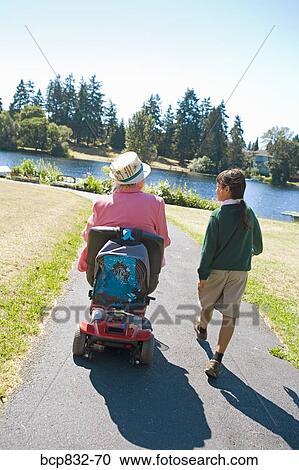Girl walking with her grandmother sitting in a wheelchair View Large Photo Image Stock Image - Girl walking with her grandmother sitting in a wheelchair. Fotosearch