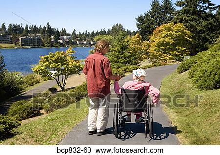 Man assisting his disabled mother in a wheelchair View Large Photo Image Stock Image - Man assisting his disabled mother in a wheelchair. Fotosearch