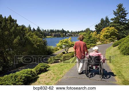 Man assisting his disabled mother in a wheelchair View Large Photo Image Stock Image - Man assisting his disabled mother in a wheelchair. Fotosearch