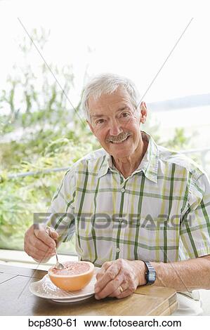 Man eating a grapefruit View Large Photo Image Stock Image - Man eating a grapefruit. Fotosearch