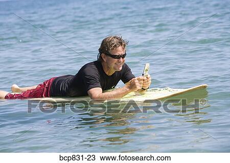 Man floating on water and text messaging View Large Photo Image Stock Image - Man floating on water and text messaging. Fotosearch