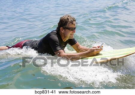 Man floating on water and text messaging View Large Photo Image Stock Image - Man floating on water and text messaging. Fotosearch