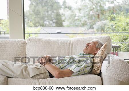 Stock Image - Man napping on a couch. Fotosearch
