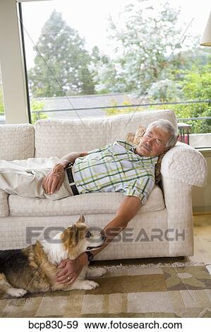 Man napping on a couch with his dog sitting beside him View Large Photo Image Stock Photo - Man napping on a couch with his dog sitting beside him. Fotosearch