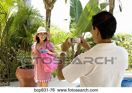 Stock Photograph - Man photographing a woman smiling. Fotosearch