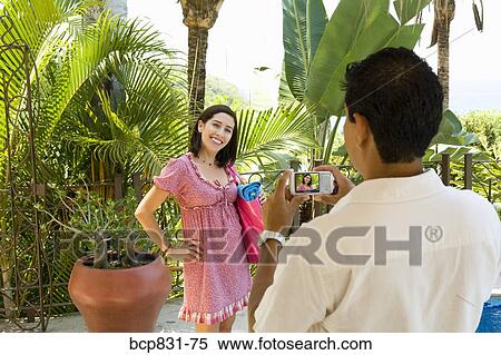 Stock Photography - Man photographing a woman smiling. Fotosearch
