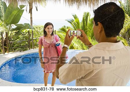 Man photographing his wife at the poolside View Large Photo Image Stock Photo - Man photographing his wife at the poolside. Fotosearch