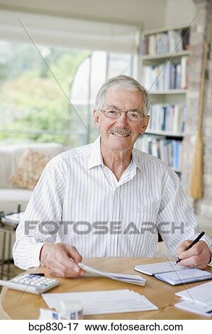 Stock Photo - Man preparing home finance budget. Fotosearch