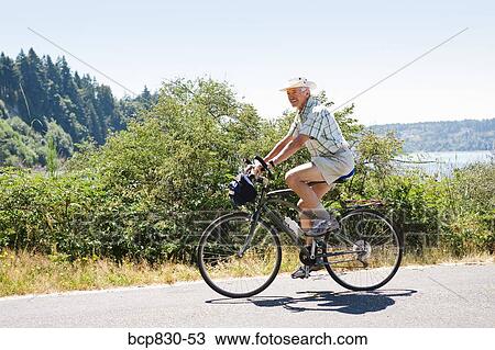 Man riding a bicycle on a road, Washington State, USA View Large Photo Image Stock Image - Man riding a bicycle on a road, Washington State, USA. Fotosearch
