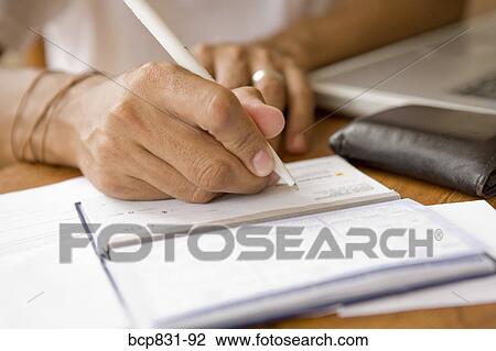 Man signing a check and preparing home finance budget View Large Photo Image Stock Image - Man signing a check and preparing home finance budget. Fotosearch