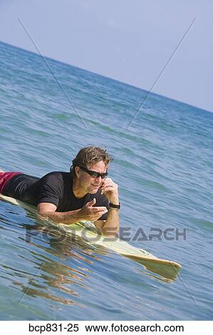 Man surfing and talking on the phone View Large Photo Image Stock Photography - Man surfing and talking on the phone. Fotosearch