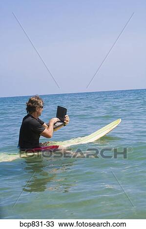 Man surfing and using a laptop View Large Photo Image Stock Image - Man surfing and using a laptop. Fotosearch