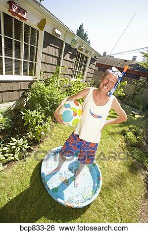 Man wearing snorkel and holding a ball in a wadding pool View Large Photo Image Stock Photograph - Man wearing snorkel and holding a ball in a wadding pool. Fotosearch