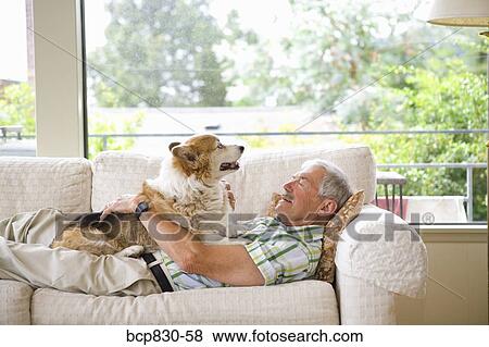 Man with his dog on a couch View Large Photo Image Stock Photo - Man with his dog on a couch. Fotosearch