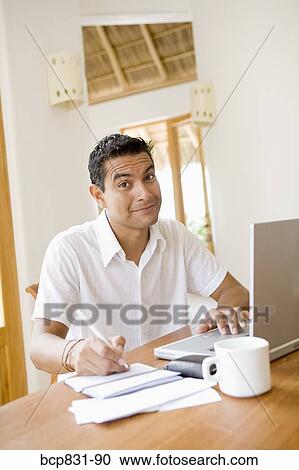 Man working on a laptop and preparing home finance budget View Large Photo Image Stock Image - Man working on a laptop and preparing home finance budget. Fotosearch