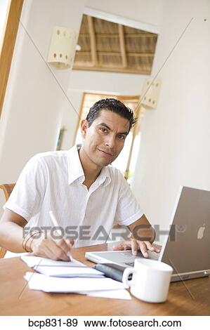 Man working on a laptop and preparing home finance budget View Large Photo Image Stock Photo - Man working on a laptop and preparing home finance budget. Fotosearch