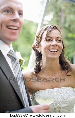 Newlywed couple smiling and holding a champagne flute, East Meredith, New York State, USA View Large Photo Image Stock Photo - Newlywed couple smiling and holding a champagne flute, East Meredith, New York State, USA. Fotosearch