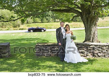 Stock Photography - Newlywed couple standing in a park, East Meredith, New York State, USA. Fotosearch
