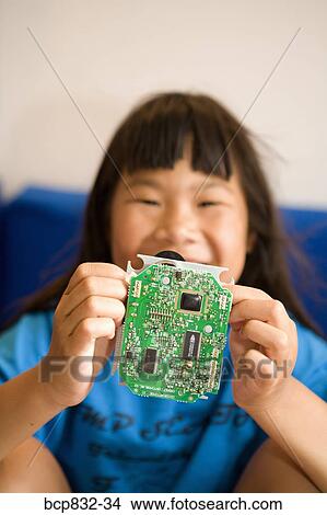 Portrait of a girl holding a circuit board View Large Photo Image Picture - Portrait of a girl holding a circuit board. Fotosearch