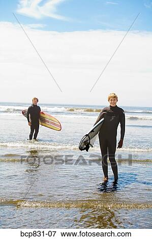 Surfers holding surfboards on the beach, Washington State, USA View Large Photo Image Stock Photo - Surfers holding surfboards on the beach, Washington State, USA. Fotosearch