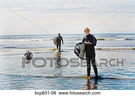 Surfers holding surfboards on the beach, Washington State, USA View Large Photo Image Stock Photo - Surfers holding surfboards on the beach, Washington State, USA. Fotosearch