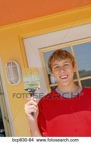 Teenage boy holding a paintbrush View Large Photo Image Picture - Teenage boy holding a paintbrush. Fotosearch