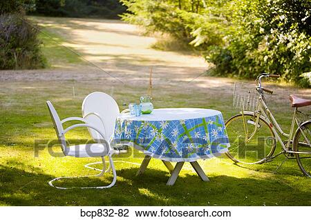 Two chairs with a table and a bicycle in a garden View Large Photo Image Stock Image - Two chairs with a table and a bicycle in a garden. Fotosearch