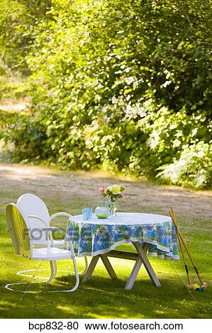 Two chairs with a table and croquet mallets in a garden View Large Photo Image Stock Image - Two chairs with a table and croquet mallets in a garden. Fotosearch