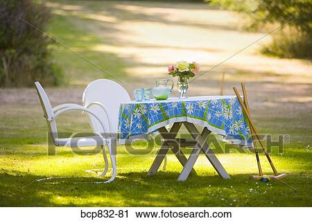 Two chairs with a table and croquet mallets in a garden View Large Photo Image Stock Image - Two chairs with a table and croquet mallets in a garden. Fotosearch