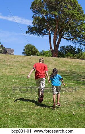 Stock Image - Two friends playing in a park. Fotosearch