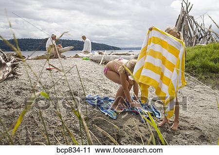Two girls with their family on the beach View Large Photo Image Stock Image - Two girls with their family on the beach. Fotosearch