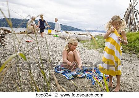 Two girls with their family on the beach View Large Photo Image Stock Image - Two girls with their family on the beach. Fotosearch