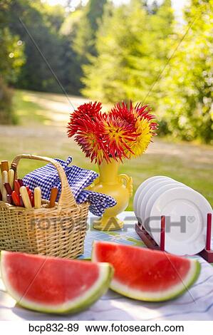 Two watermelon slices with a basket and a vase of flowers on a table View Large Photo Image Stock Photo - Two watermelon slices with a basket and a vase of flowers on a table. Fotosearch