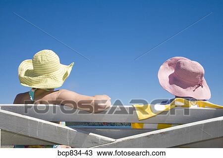 Stock Image - Two women sitting on the bench. Fotosearch